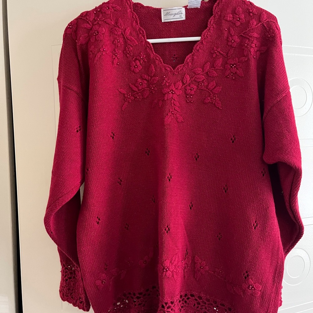 Red sweater with padded shoulders, v- neck that is embellished